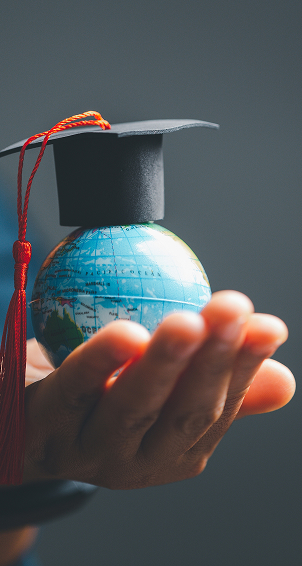 holding globe with graduation cap